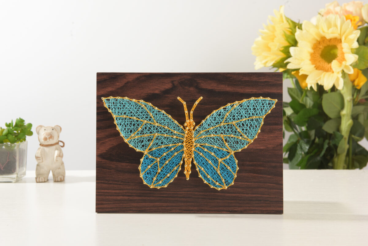 String art butterfly on wooden board
