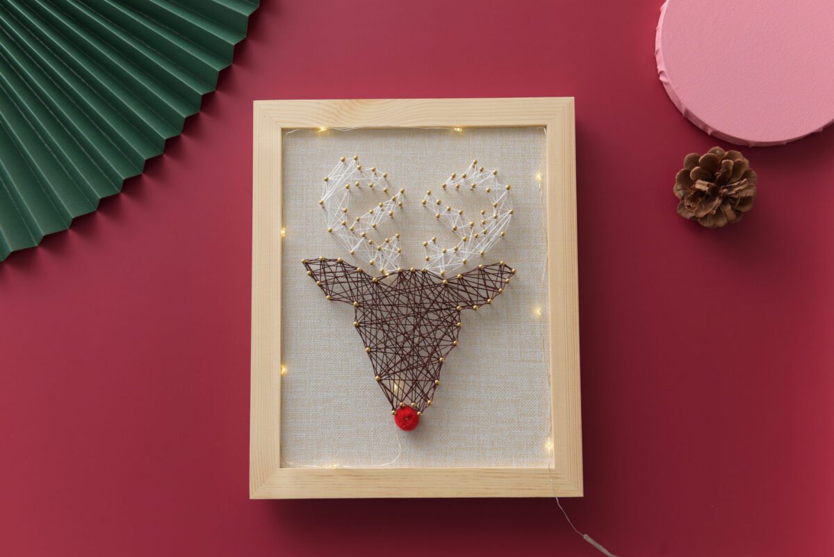 Reindeer Christmas string art with red nose and golden nails