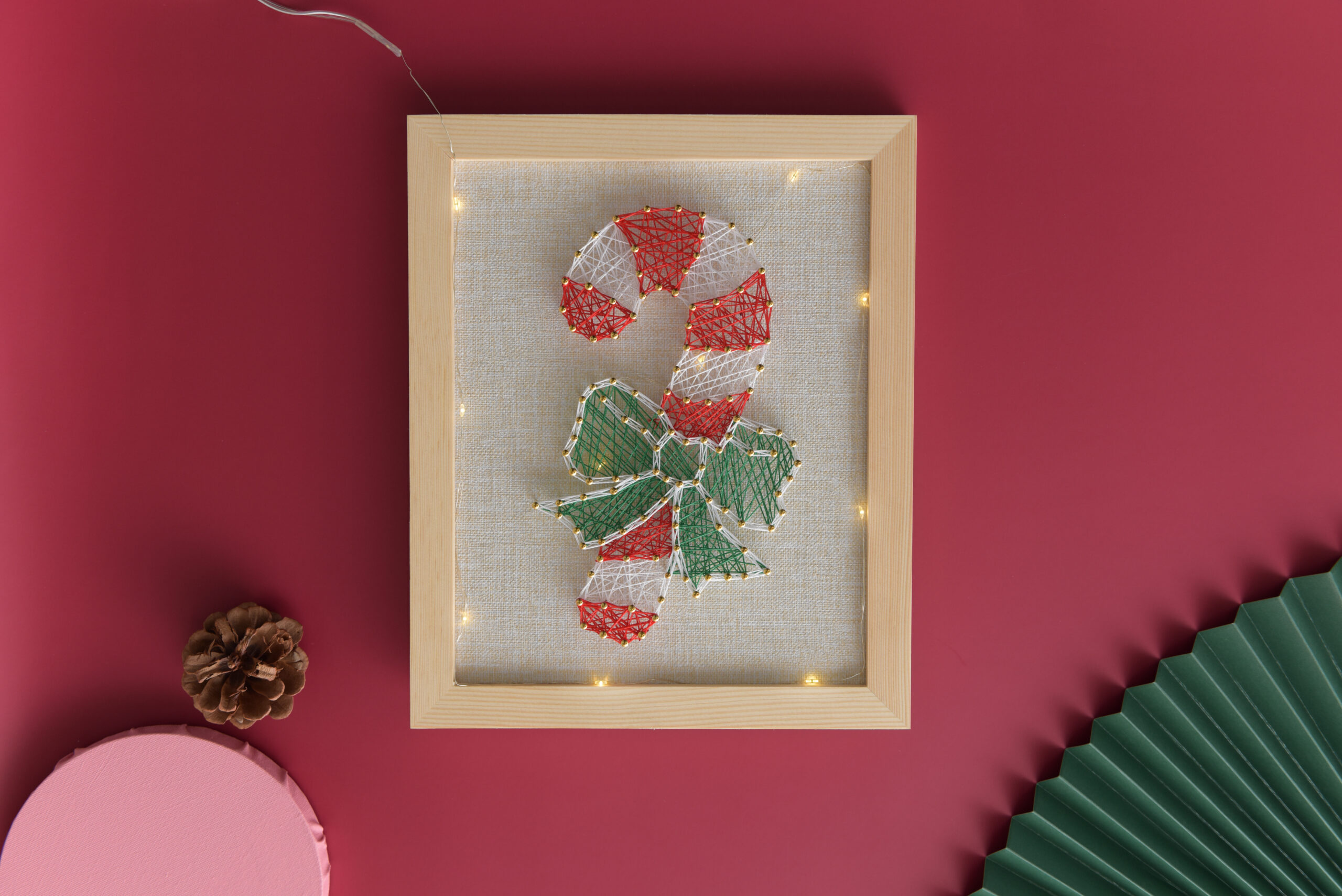 Candy cane string art with green ribbon and red-white thread
